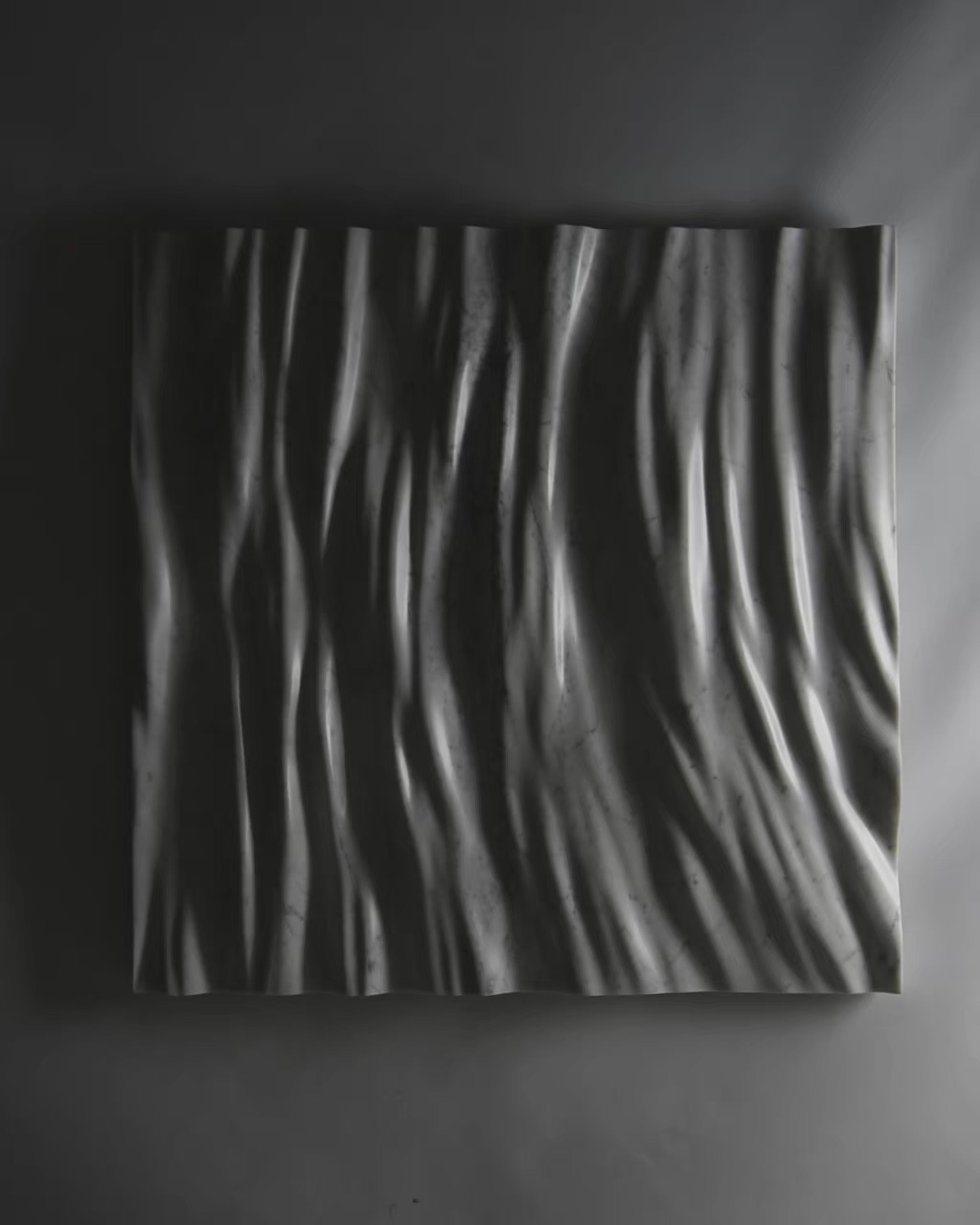 Video showing the Eternal Carrara marble wall sculpture with dramatic light and shadow across the folds