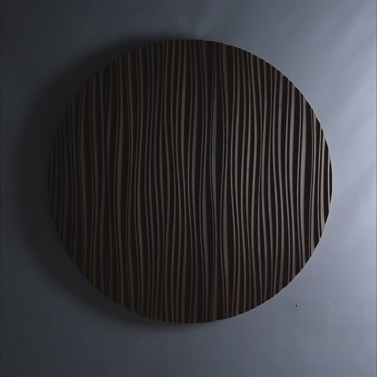 A circular Iroko ‘The Line’ panel mounted above a sofa, blending big wall decor appeal with scandi interior elegance in a softly lit space