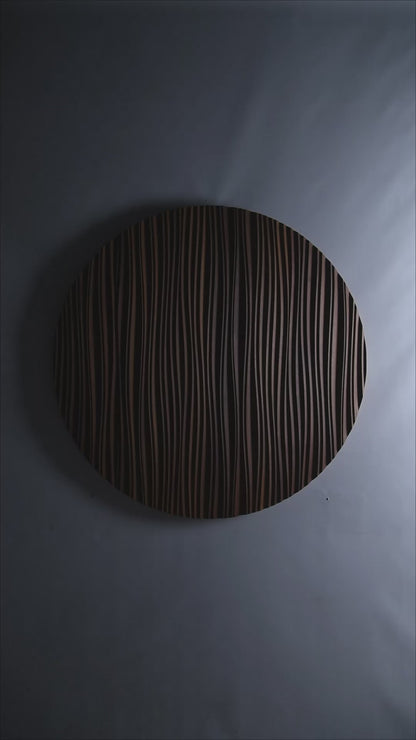 A circular Iroko ‘The Line’ panel mounted above a sofa, blending big wall decor appeal with scandi interior elegance in a softly lit space