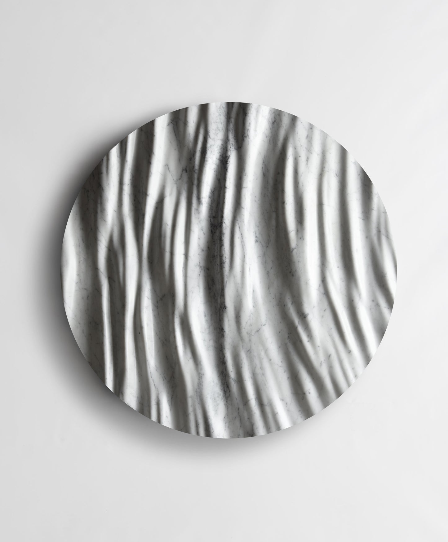 Round Eternal Carrara marble wall sculpture front view with flowing vertical folds and natural grey veining