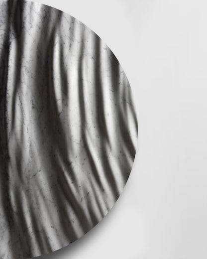 Side detail of the Round Eternal Carrara marble sculpture showing carved depth, edge thickness, and soft shadows