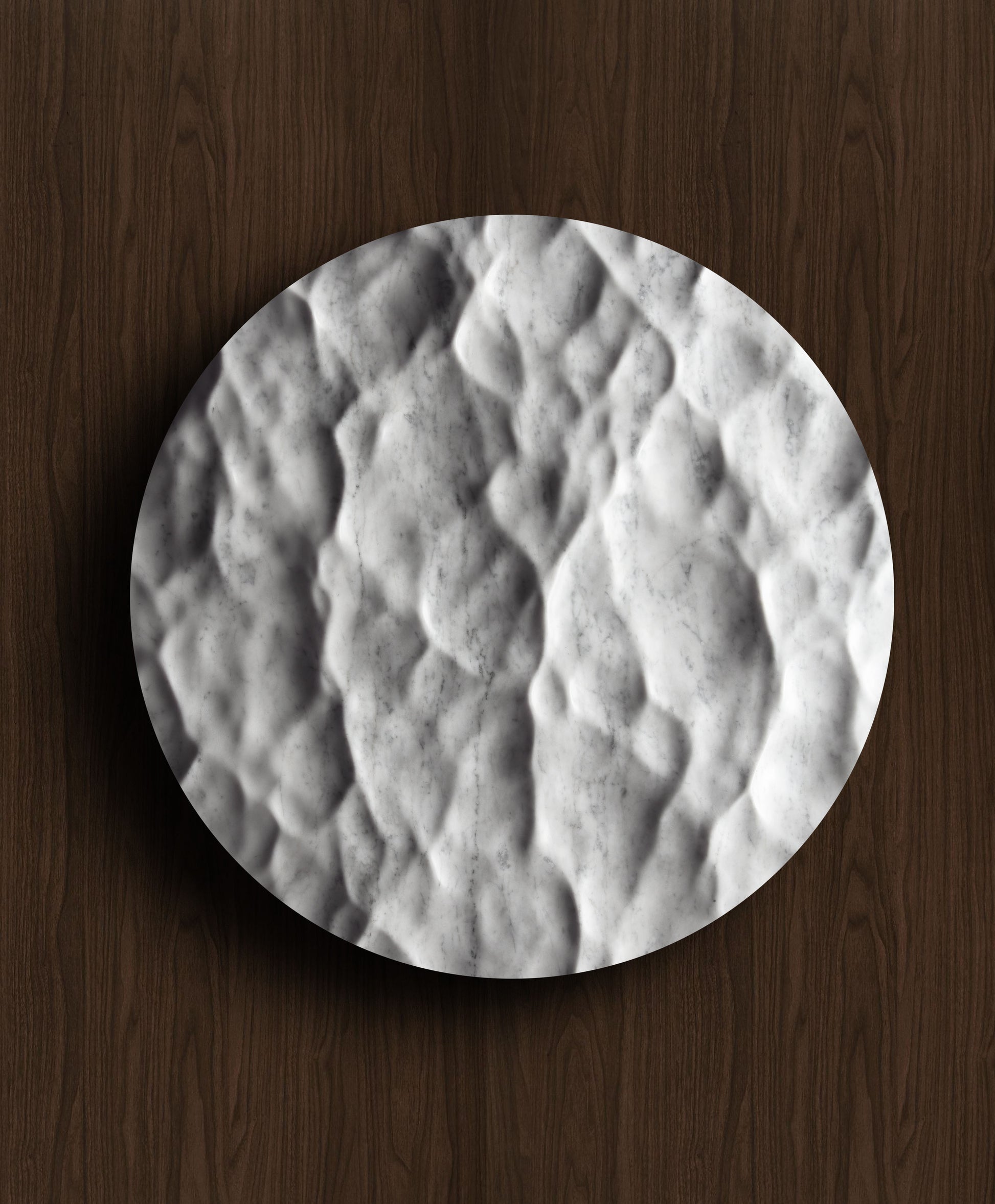 Round Liquid Marble Carrara wall sculpture displayed on a warm walnut background with fluid relief and natural veining