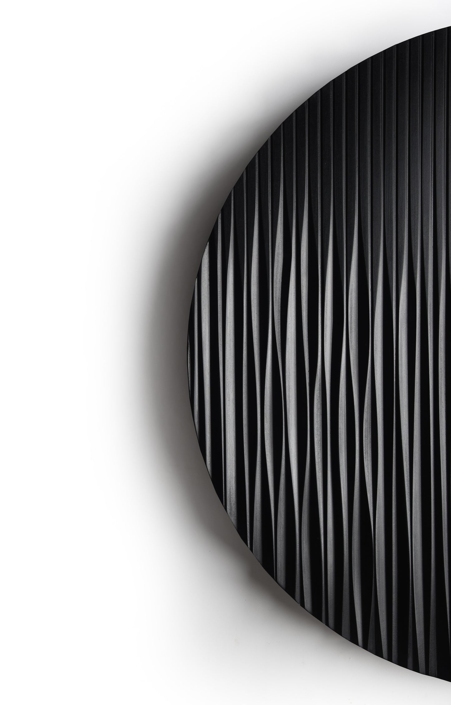 Round black wall sculpture styled above the console in a minimal interior