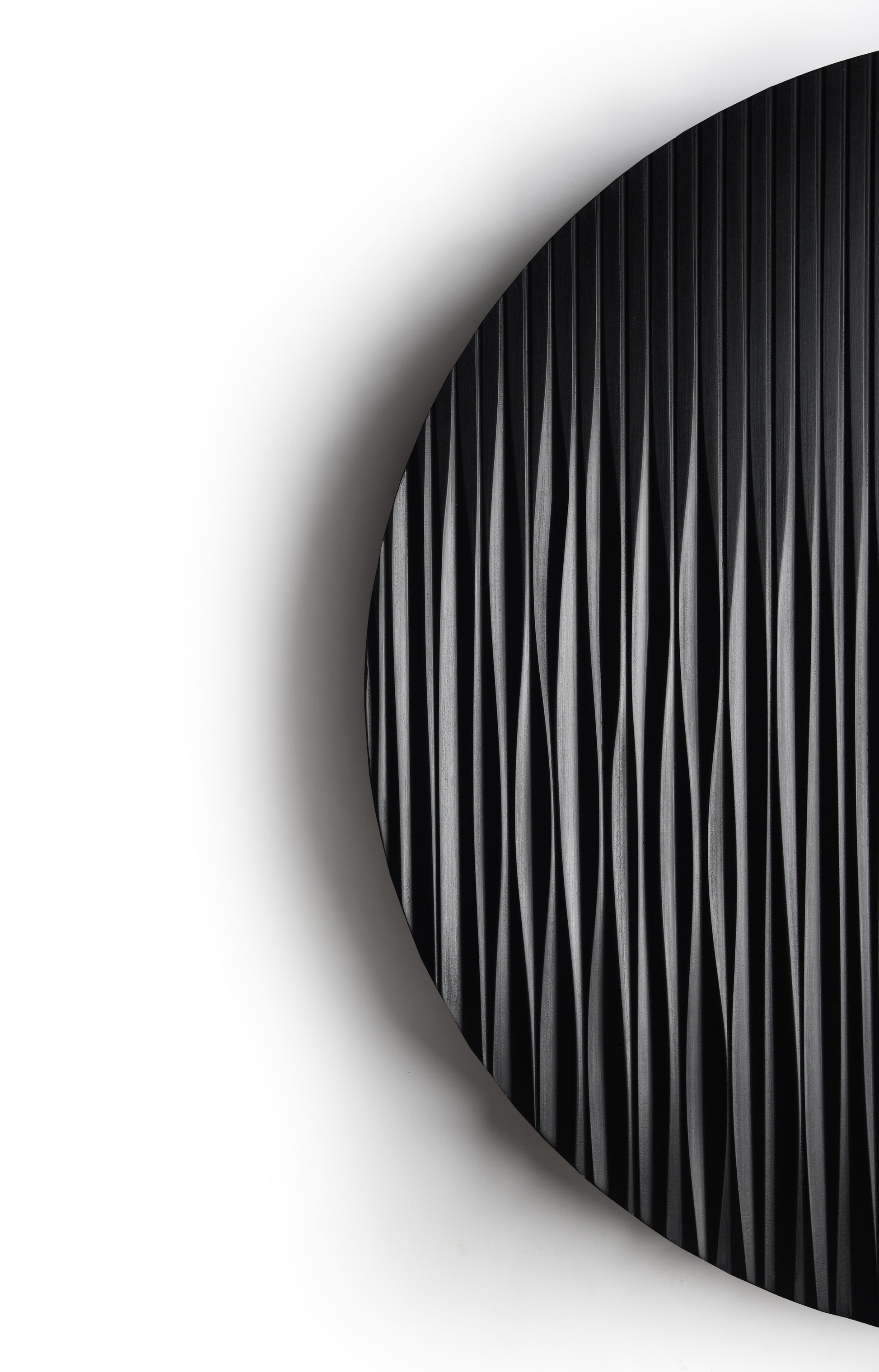 Round black wall sculpture styled above the console in a minimal interior