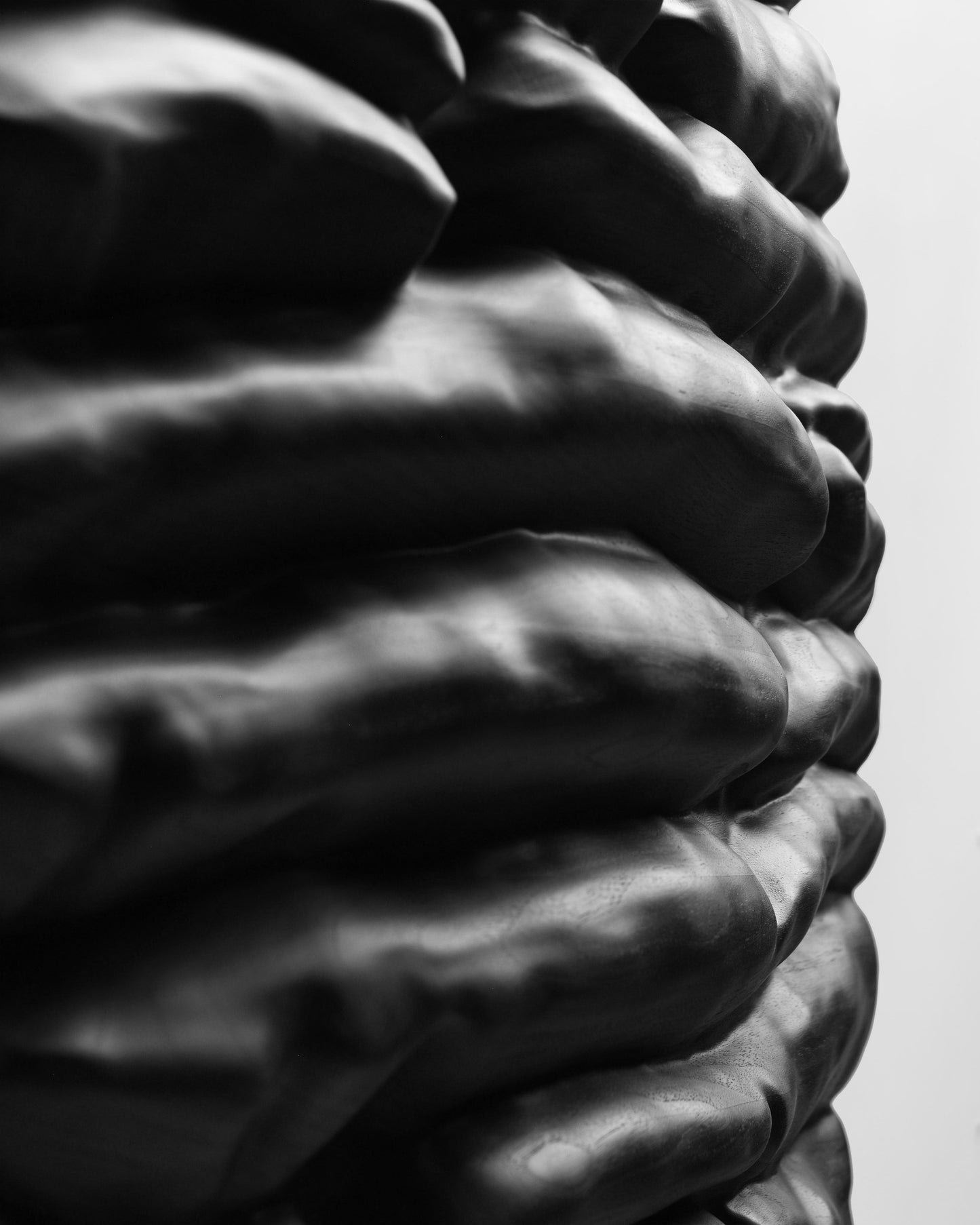 Edge close up of stacked black wood volumes on the sculptural relief of Strata Black