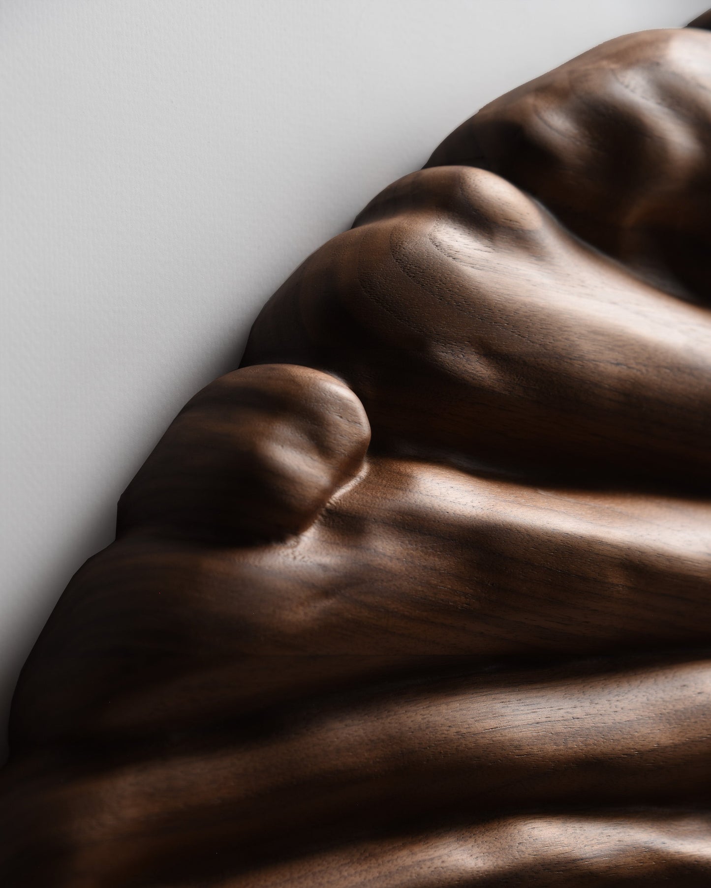 Detail of the natural walnut grain following the rounded contours of the sculptural surface