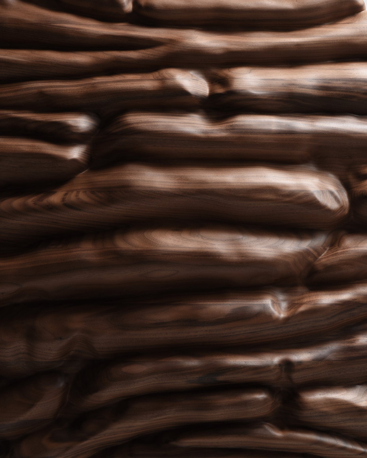 Close view of the central walnut relief showing layered forms, natural grain and softly finished surfaces