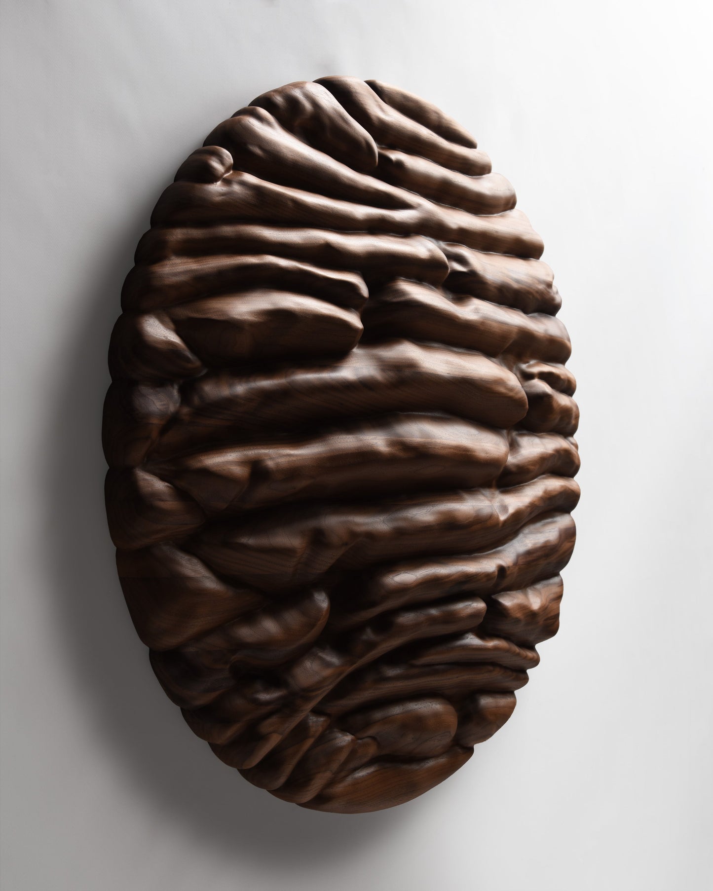 Angled view of the circular sculpture revealing its projecting forms and sculptural depth