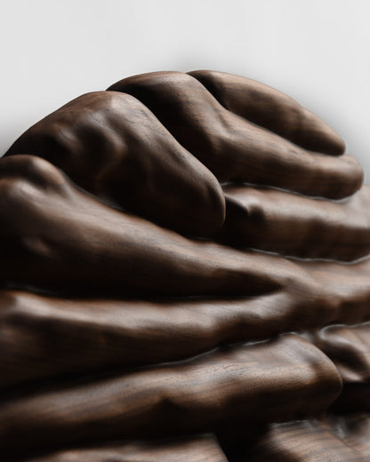 Upper section of the sculpture with broad flowing ridges carved into Canaletto walnut