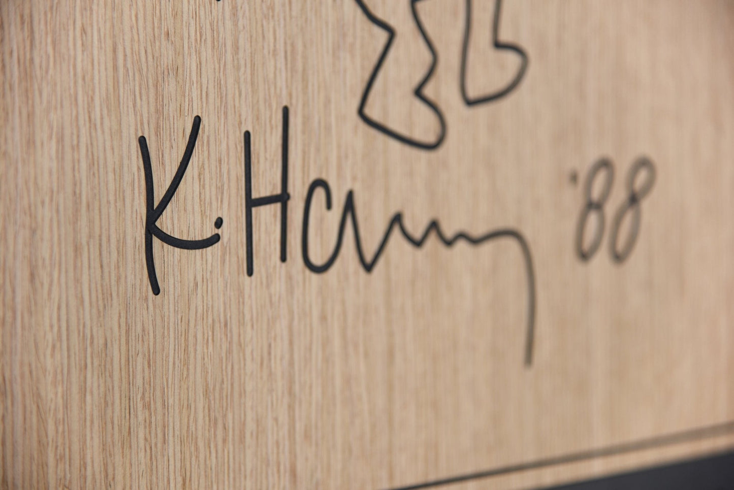 Close up detail of the engraved signature on the Stunts Keith Haring carved wood wall panel