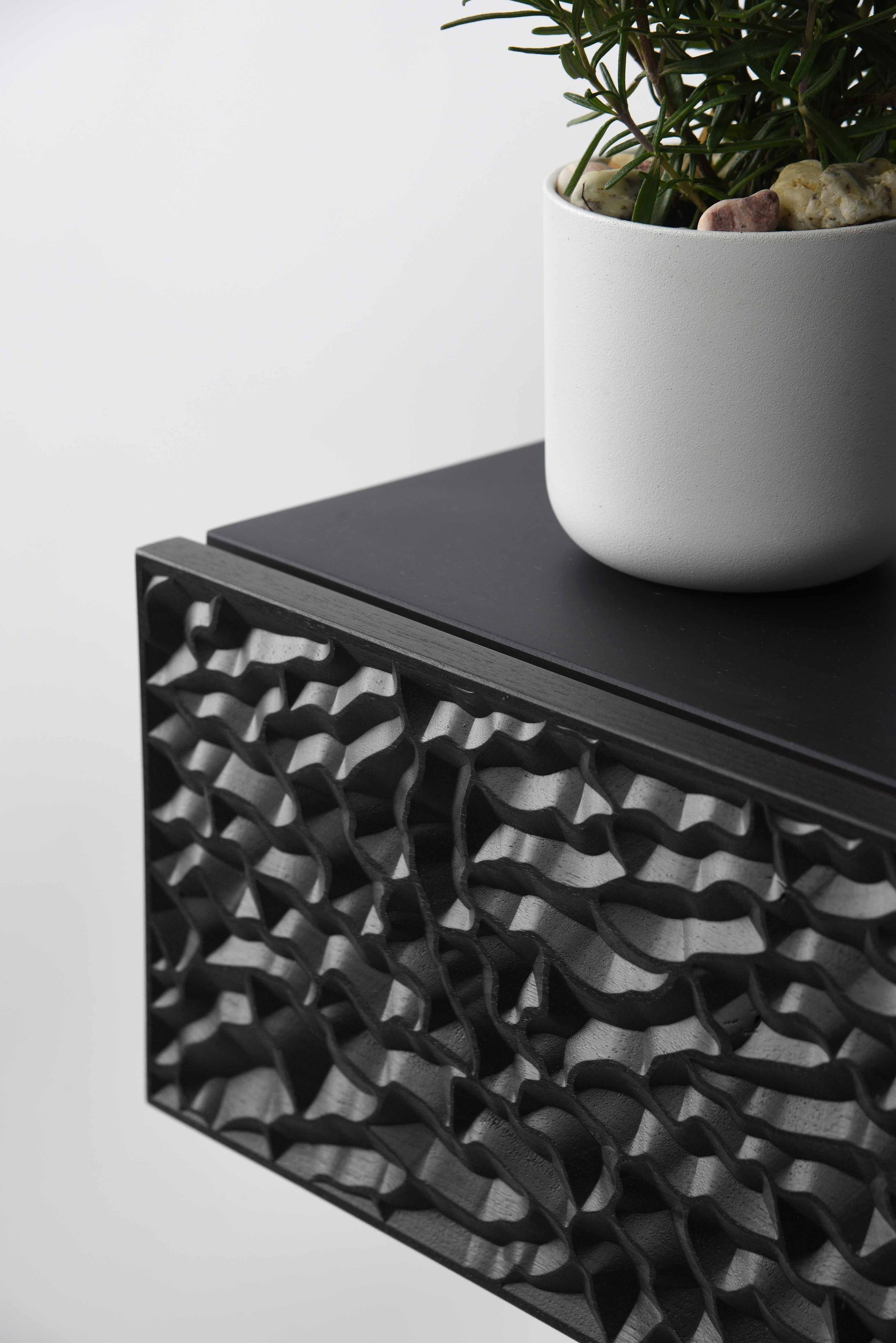 Close up of the carved relief pattern on the total black console drawer front