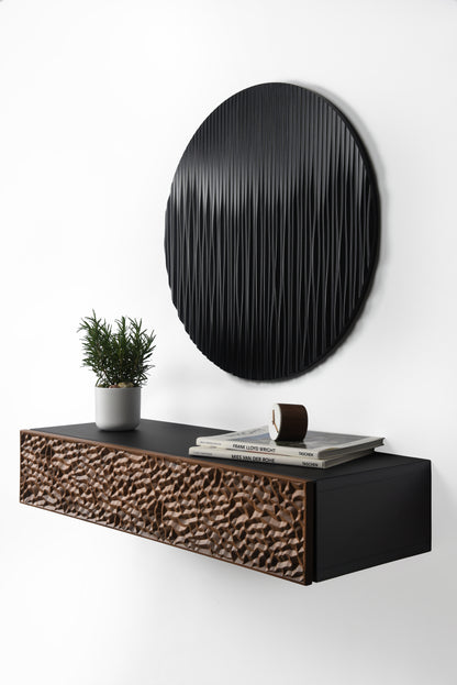 Walnut and black suspended console detail with carved front and round black wall sculpture