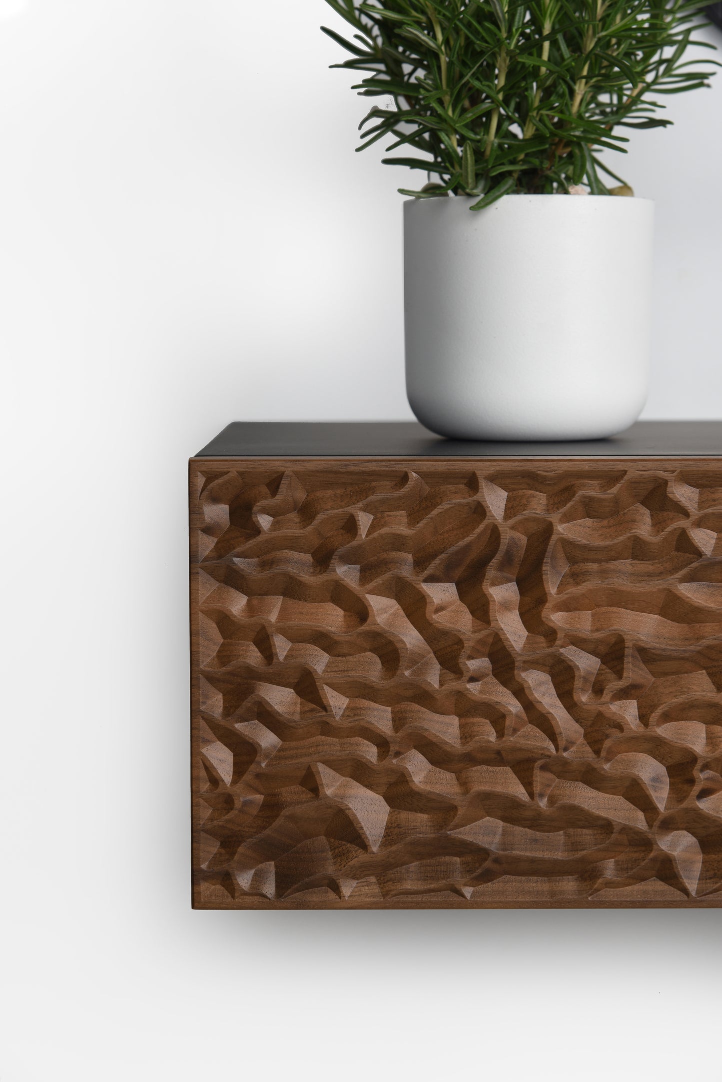 Close up of the walnut carved drawer front with black top surface