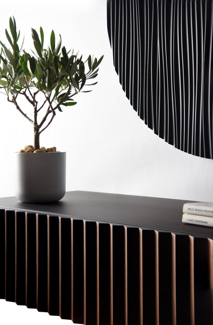 Angled interior detail of the walnut and black suspended console with sculpture partially visible