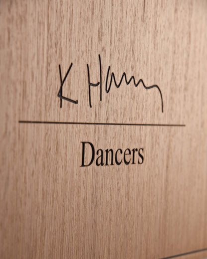 Macro detail of engraved title and wood grain on The Dancers panel