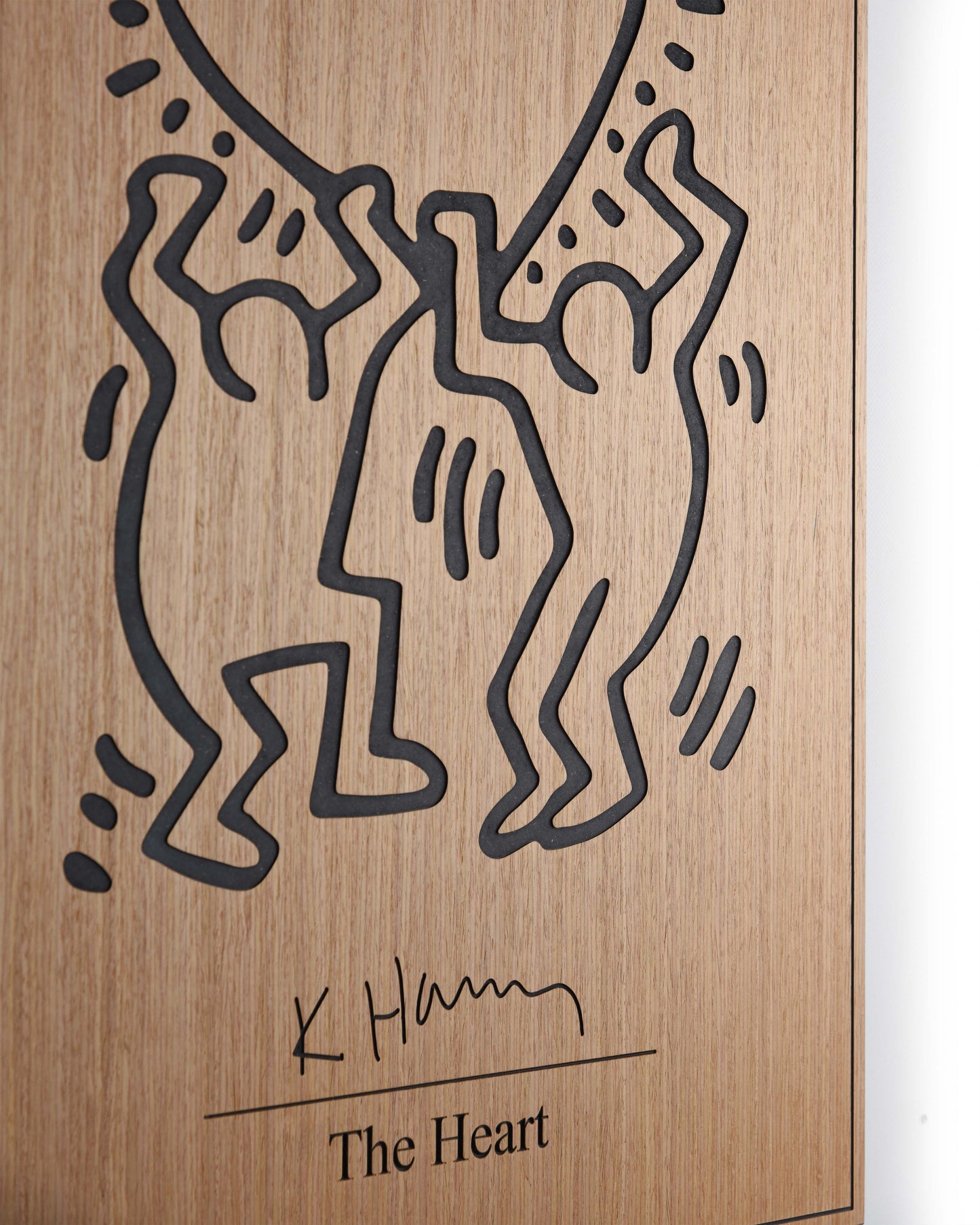 Angled detail of oak grain and black relief on The Heart Keith Haring panel