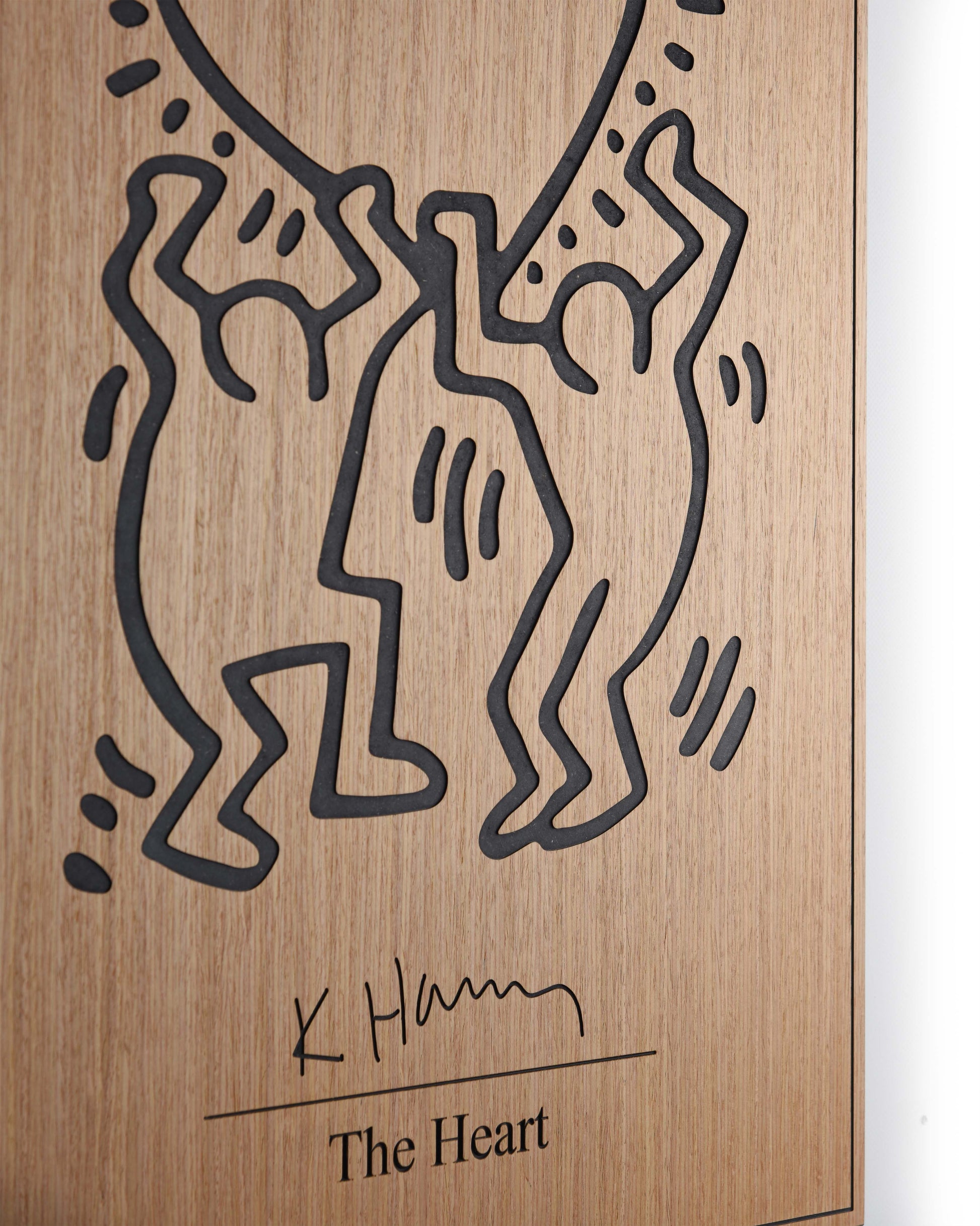 Angled detail of oak grain and black relief on The Heart Keith Haring panel