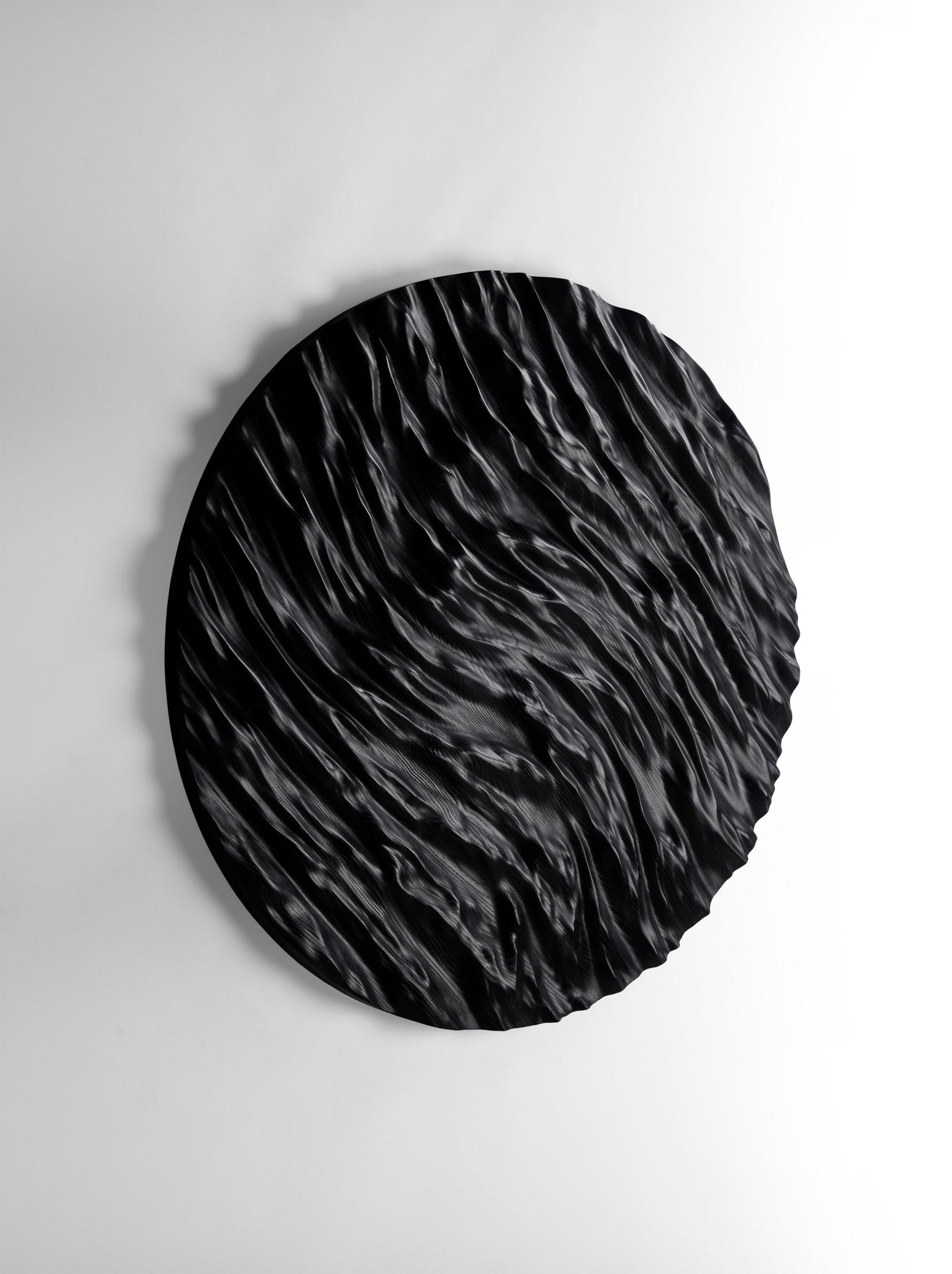 Tight focus on carved ocean ridges in black wood, ideal for new home gift ideas and refined interior decoration aesthetics.