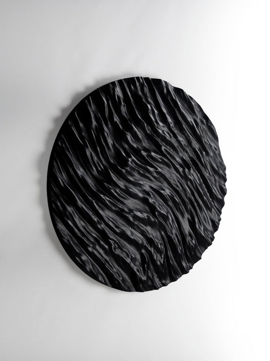 Tight focus on carved ocean ridges in black wood, ideal for new home gift ideas and refined interior decoration aesthetics.