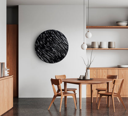 Sleek ocean-wave carving on a circular black panel, complementing a modern bathroom design and offering subtle geometry art flair.