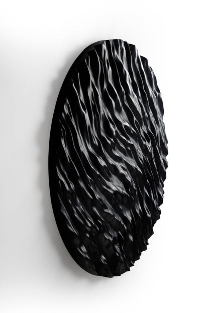 Dramatic shadows highlight wave carvings, linking boho chic interior themes with minimal house design for a unique wall statement.