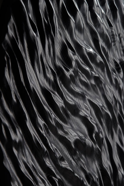 Dramatic shadows highlight wave carvings, linking boho chic interior themes with minimal house design for a unique wall statement