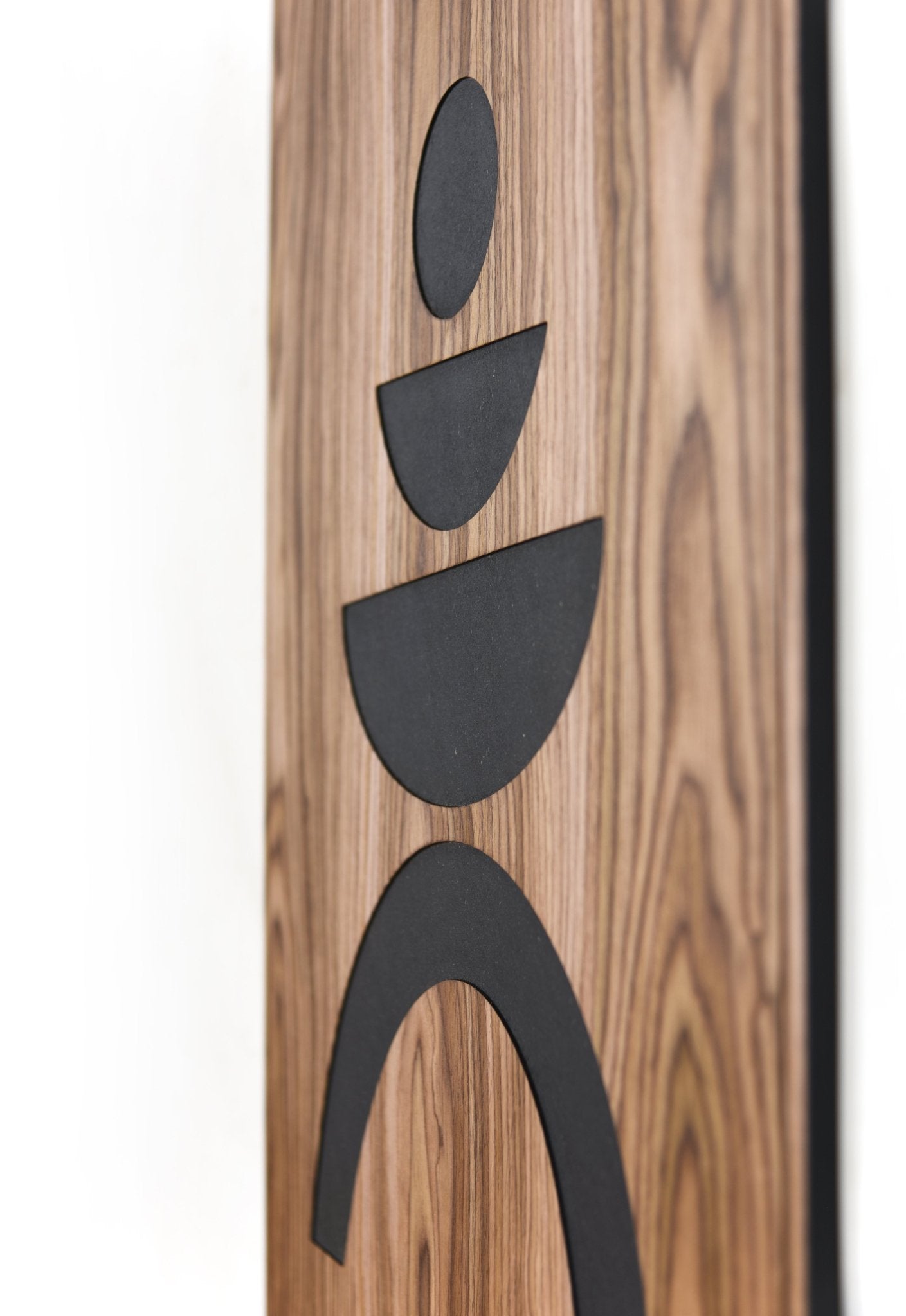 Angled close up of walnut panel showing relief depth and black shapes