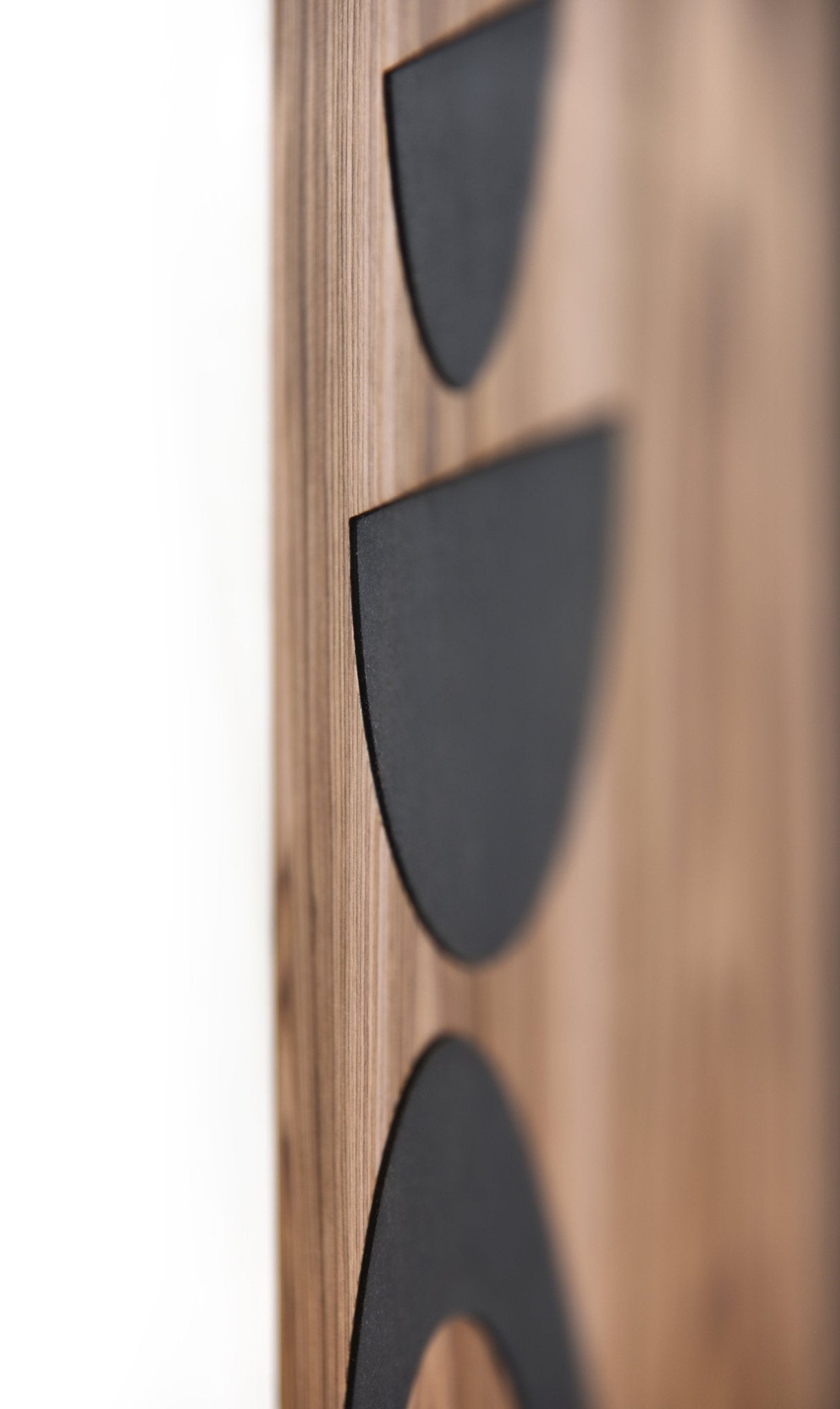 Side close up showing thickness and relief depth of black elements on walnut