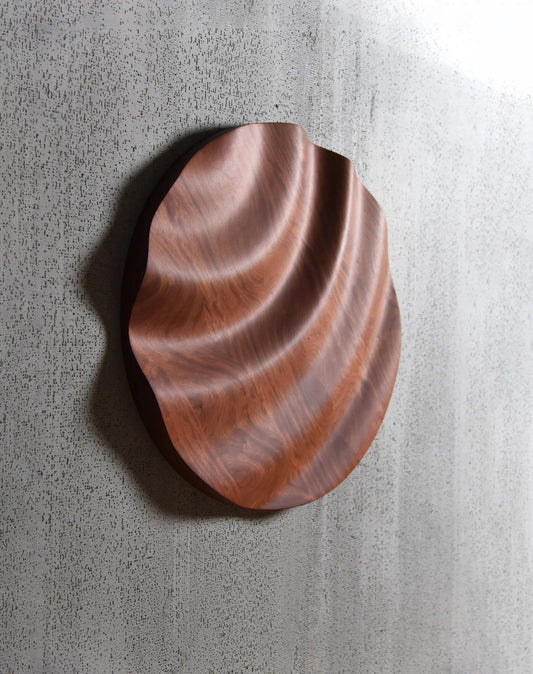 Angled perspective of wave ridges carved into circular bubinga, merging thoughtful interior decoration with wooden wall panels synergy.