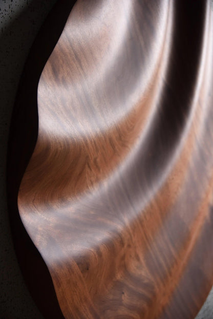 Macro angle of circular wave lines in bubinga, blending scandi interior calm and boho chic interior flair in finely etched wood patterns.