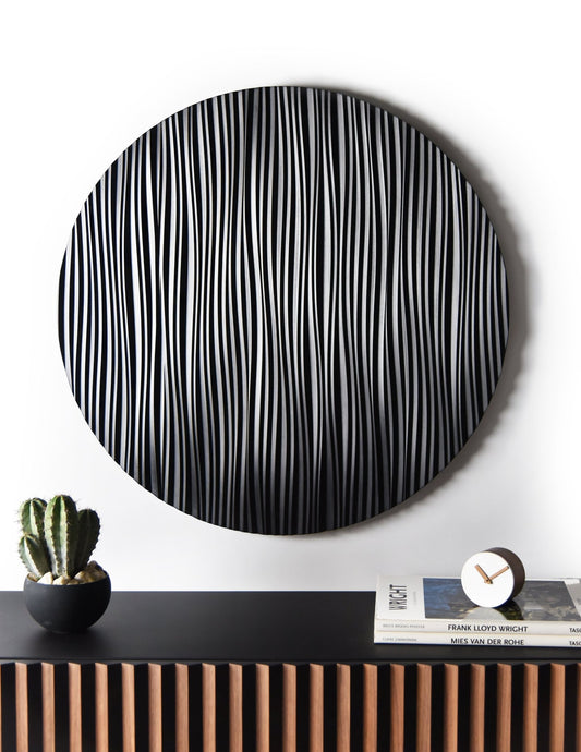 Floating walnut and black console with round Wave wall sculpture installed above in a minimal interior