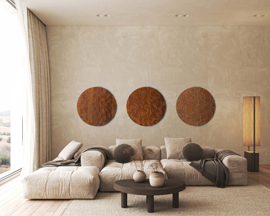Wind And Earth wall set in iroko, three round sculptures arranged above a sofa in a modern interior