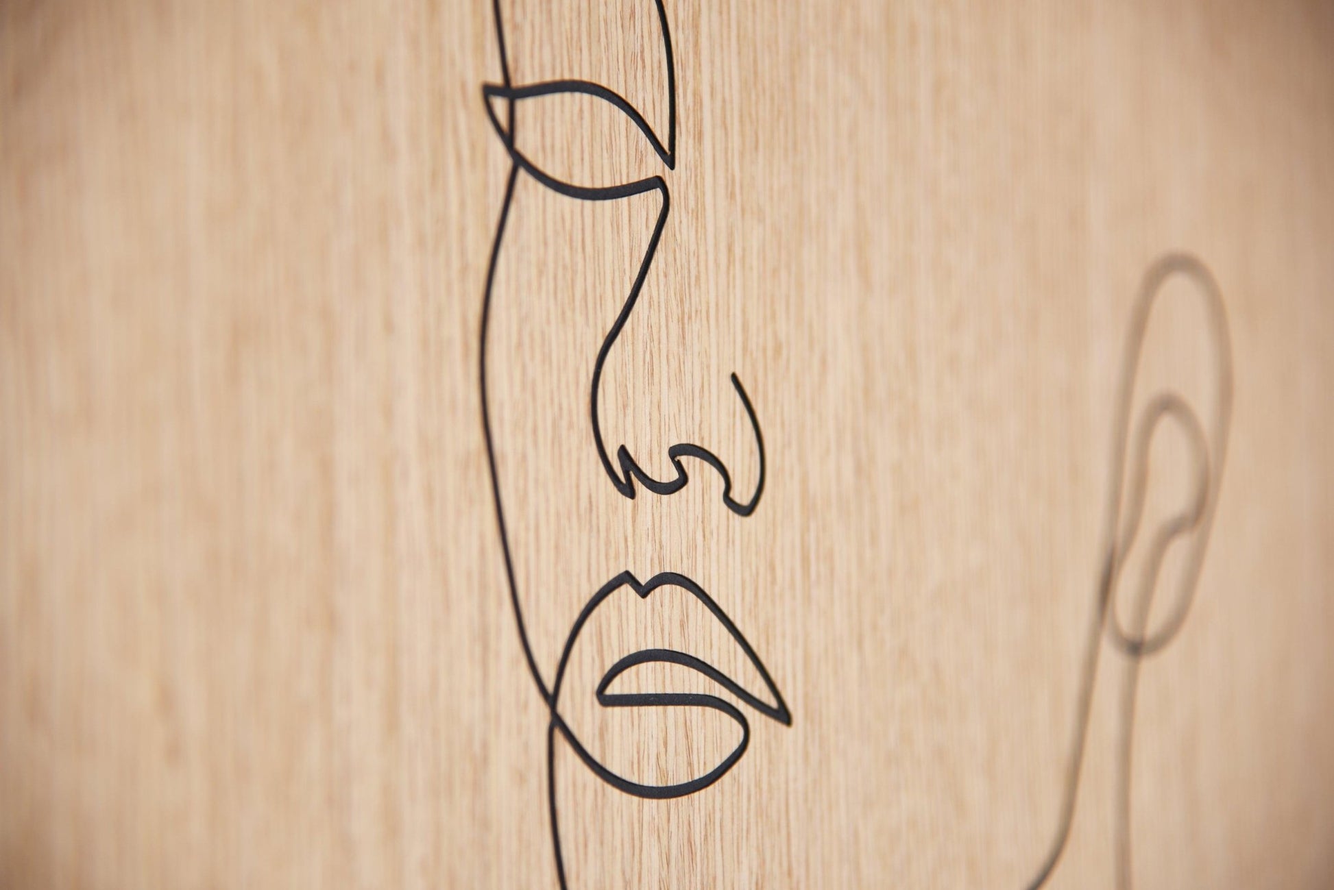 Macro detail of the carved lips and nose line on oak