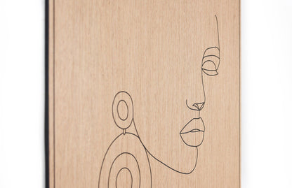Angled view of the carved line portrait on oak highlighting depth and surface texture